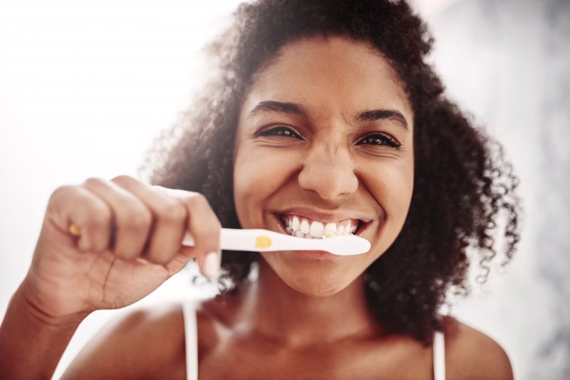 closeup of person smiling while brushing teeth